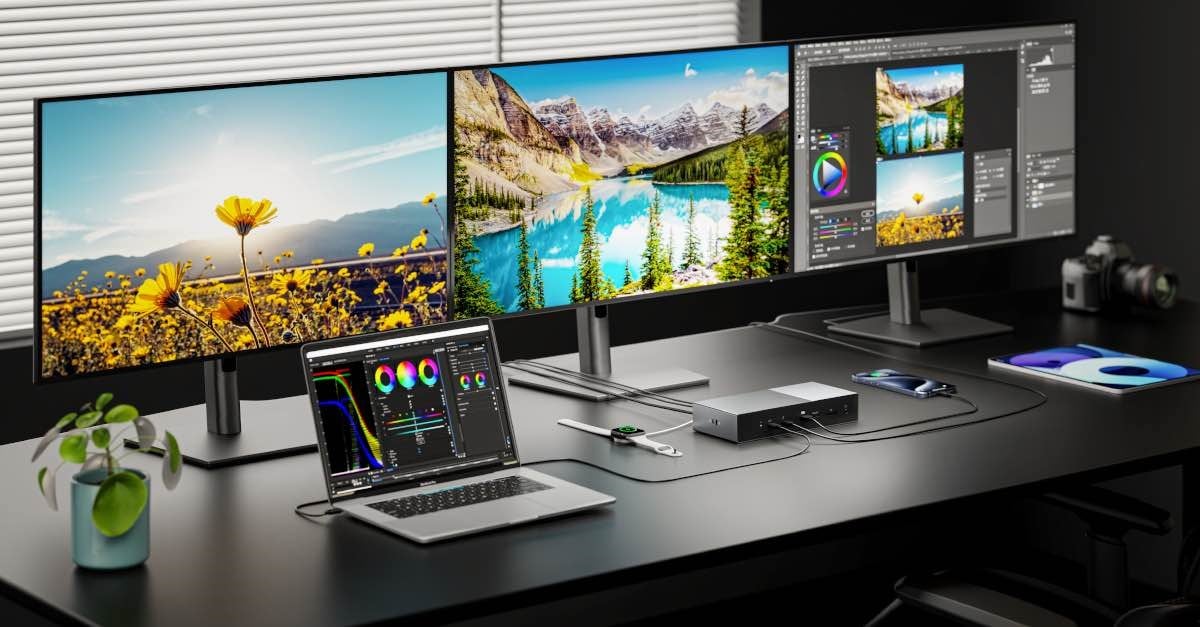A MacBook Pro on a desk with three external monitors